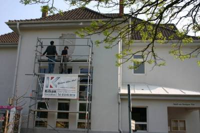 Vorbereitende Arbeiten: Die Hamburger Designerin Bettina Blick bringt die Schablone des Bennigser Wappens am Bahnhofsgebude an